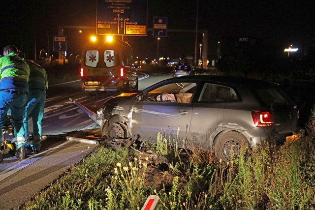 Agressieve automobilist rijdt lantaarnpaal uit de grond en wordt geboeid afgevoerd met ambulance
